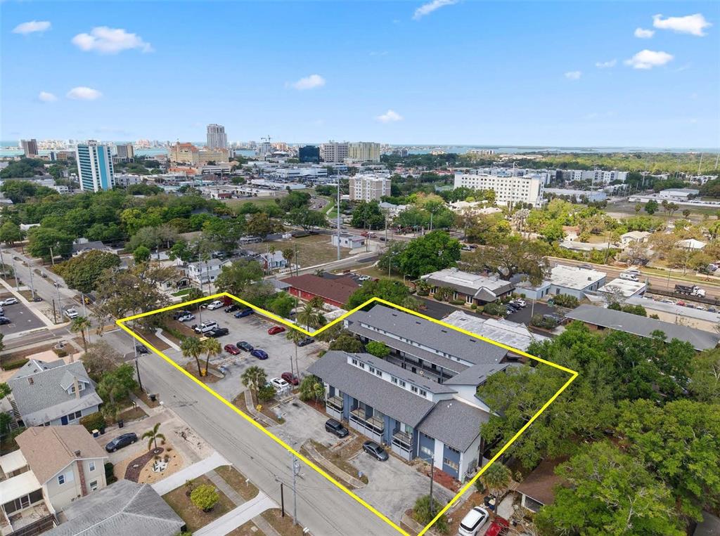 An aerial view shows a multi-story apartment building with an adjacent parking lot — 1100 TURNER STREET, CLEARWATER, FL