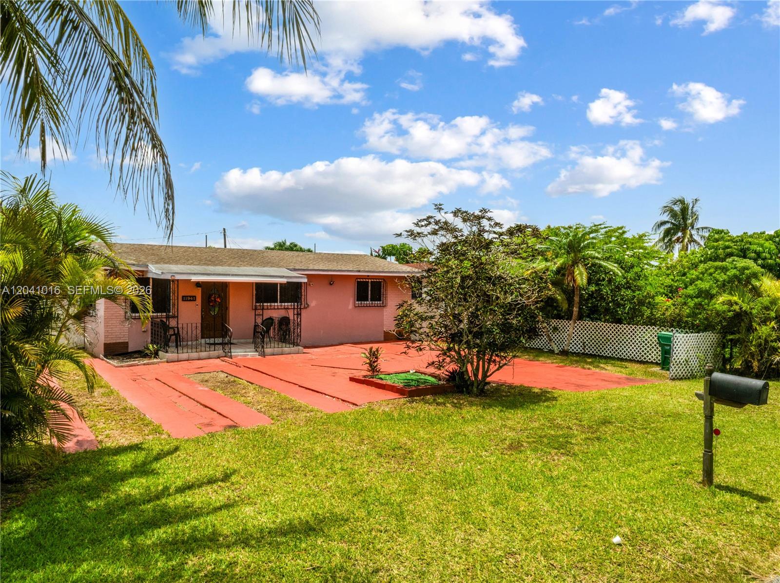 A single-story pink house features a red concrete driveway and a grassy front yard — 11941 SW 4th St, Miami FL 33184, MIAMI, FL