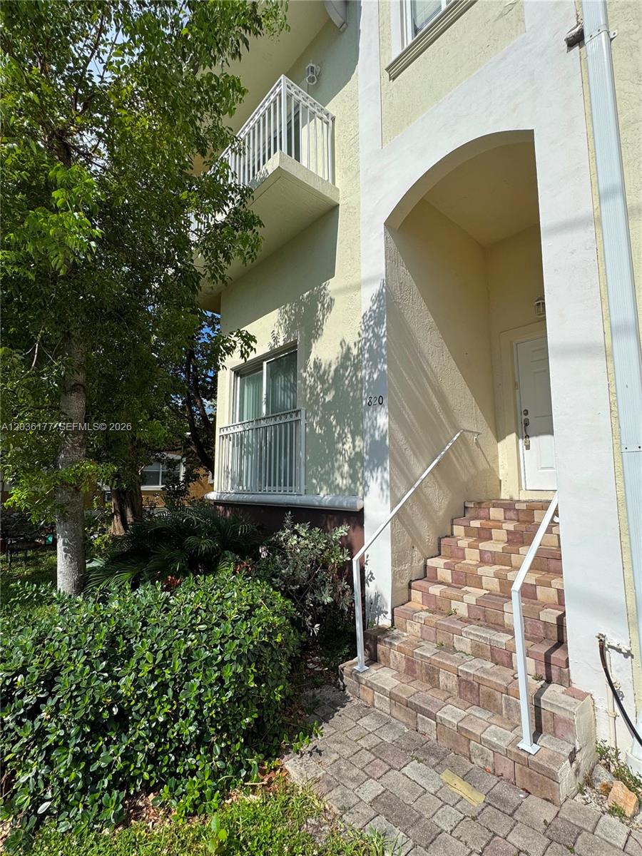 A multi-story building exterior features a paved staircase leading to a white front door — 820 N 17th Ave, Hollywood FL 33020, HOLLYWOOD, FL