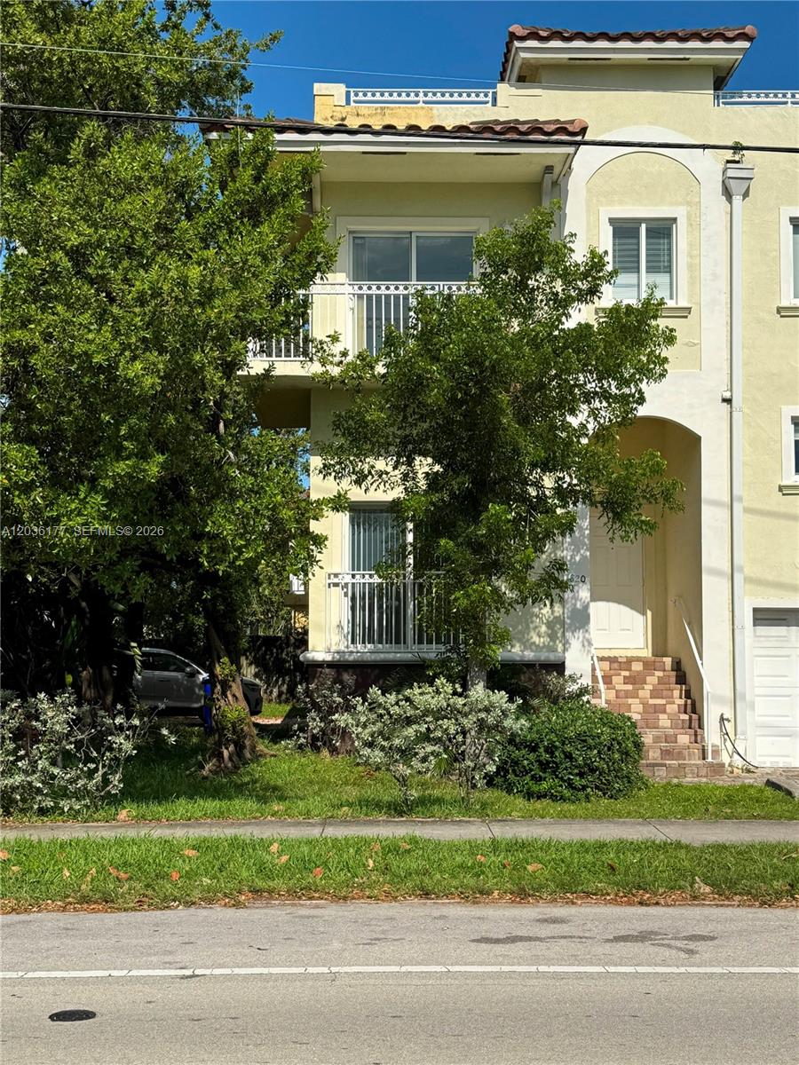 A three-story townhouse with a balcony, white exterior, and a front entrance with stairs — 820 N 17th Ave, Hollywood FL 33020, HOLLYWOOD, FL