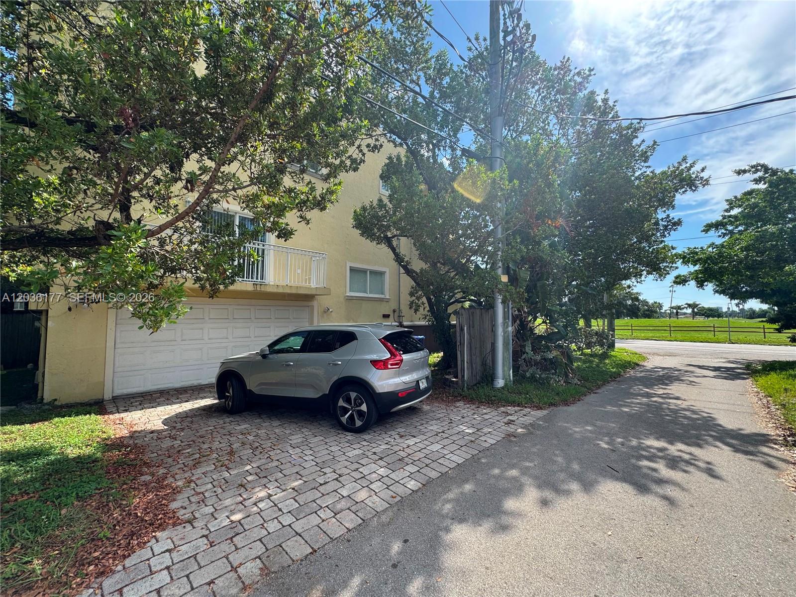 A silver SUV is parked on a paved driveway in front of a yellow house — 820 N 17th Ave, Hollywood FL 33020, HOLLYWOOD, FL