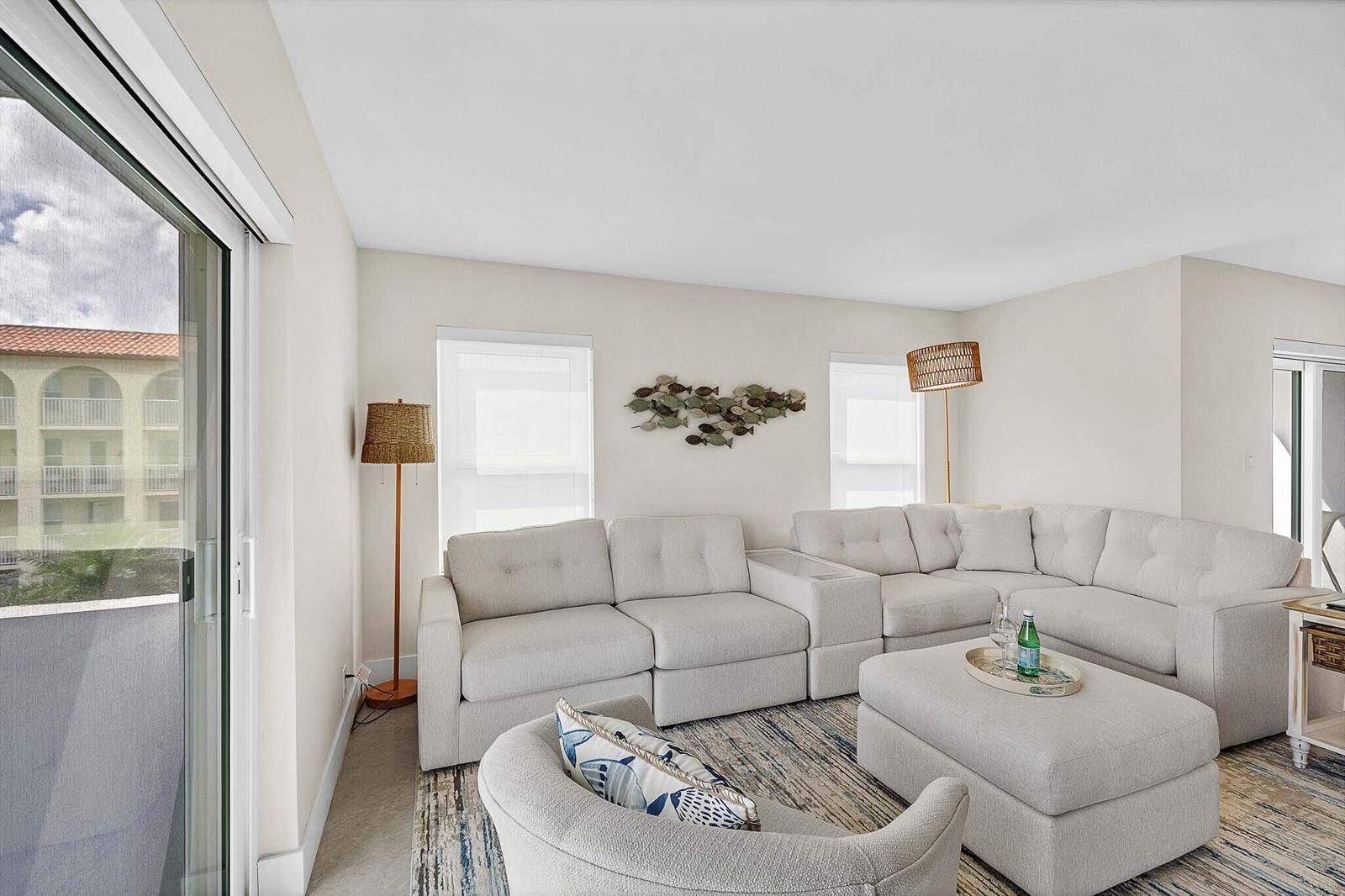 A living room features a light-colored sectional sofa, an ottoman, and a decorative fish wall sculpture — 1111 S Ocean Boulevard # 414, Boca Raton FL 33432, BOCA RATON, FL