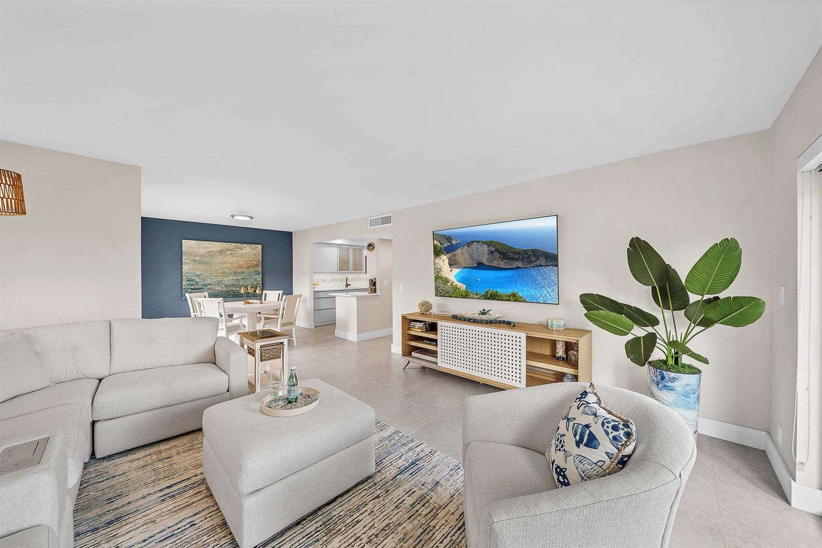 A living room features a sectional sofa, an armchair, a television, and a dining area — 1111 S Ocean Boulevard # 414, Boca Raton FL 33432, BOCA RATON, FL