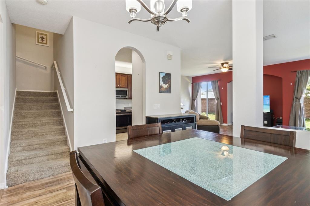 A dining area with a glass-topped table leads to a kitchen and a living room — 1947 ESTANCIA CIRCLE UNIT 8C, KISSIMMEE, FL
