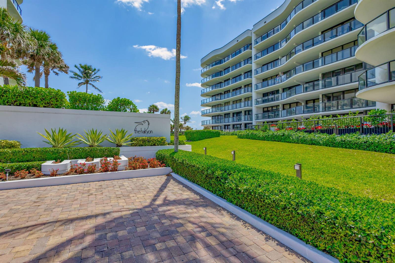 A multi-story residential building stands behind a landscaped lawn and a paved entrance area — 3440 S Ocean Boulevard # 105s, Palm Beach FL 33480, PALM BEACH, FL