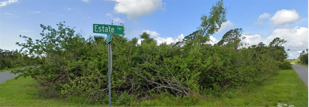 A street sign labeled Estate Ter stands in front of a dense, overgrown brushy lot — 15269 ESTATE TERRACE, PORT CHARLOTTE, FL