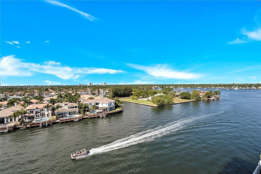 An aerial view of a waterfront residential area with a boat traveling on the canal — 1400 S Ocean Dr # 1004, Hollywood FL 33019, HOLLYWOOD, FL