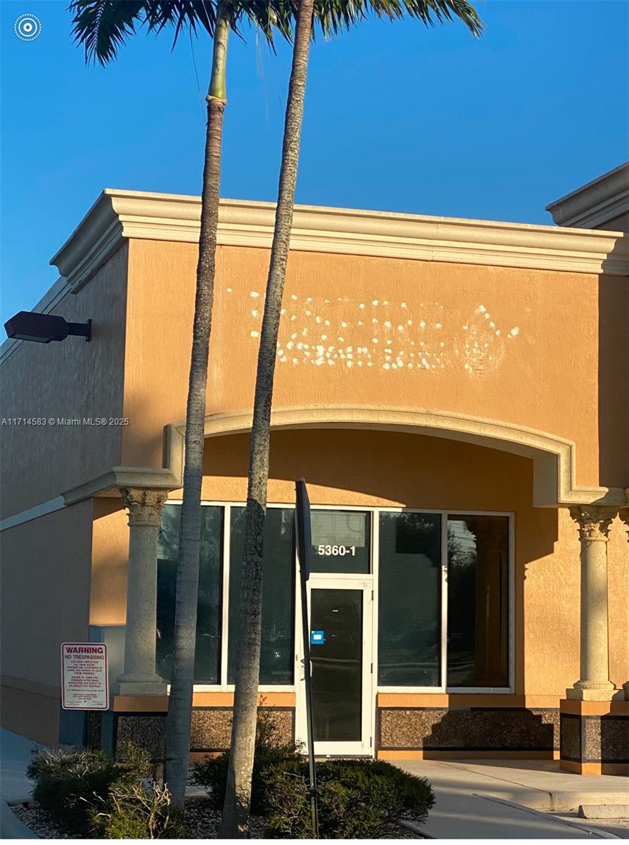 A tan commercial storefront features a glass door, large windows, and two palm trees — 5360 S University Dr, Davie FL 33328, DAVIE, FL
