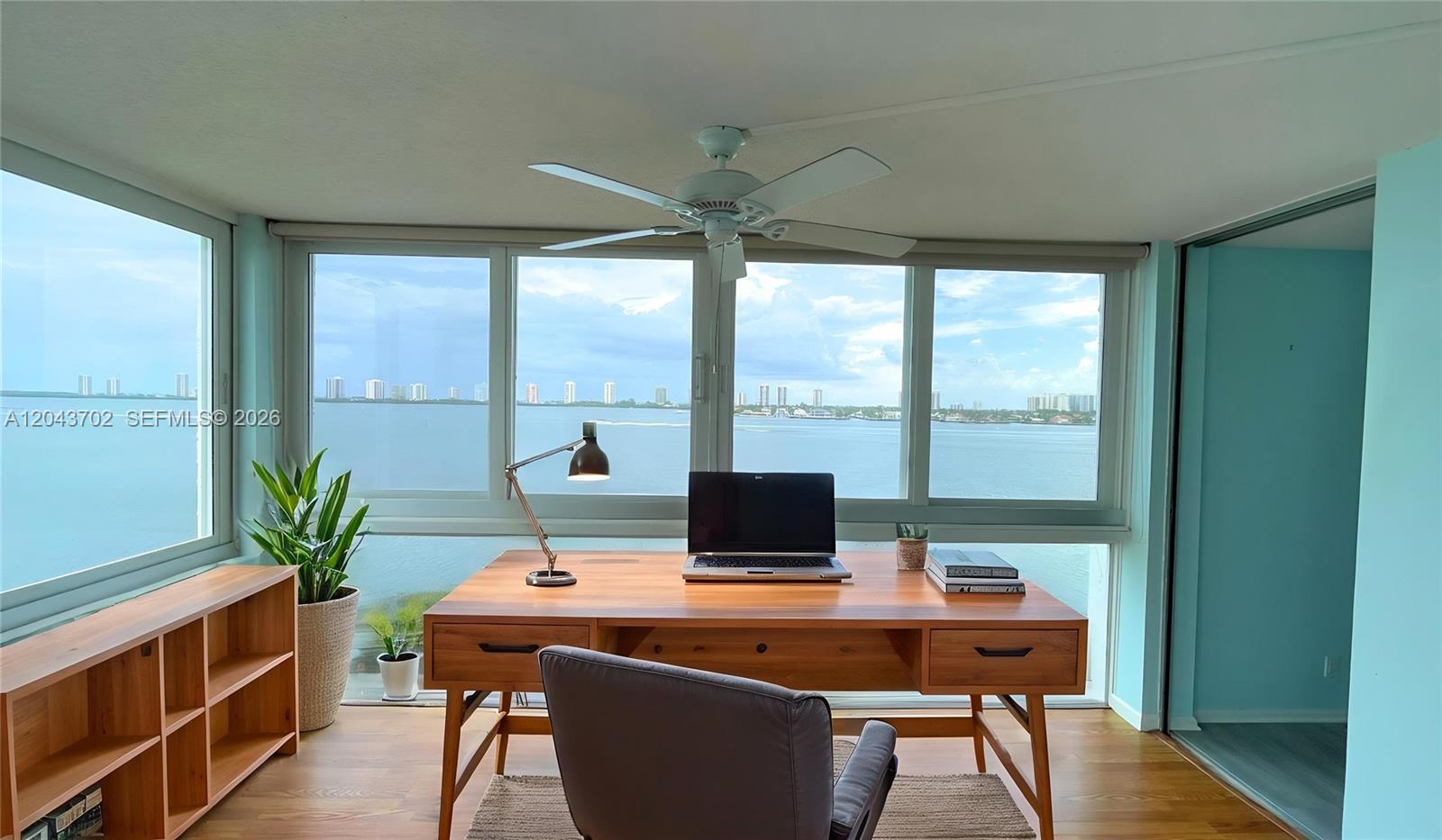 A home office features a wooden desk facing large windows with a panoramic water view — 401 Lake Shore Dr # 801, Lake Park FL 33403, LAKE PARK, FL