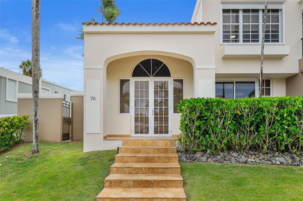 A beige house exterior features a stone staircase leading to a white arched double door — 11 VIAJERA UNIT 76, GUAYNABO, PR