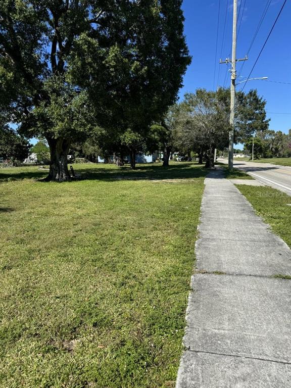 A grassy vacant lot sits next to a concrete sidewalk and a utility pole — 201 N 29TH STREET, FORT PIERCE, FL