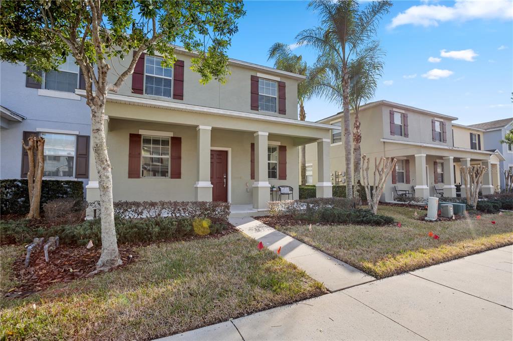 A two-story house with a front porch, tan stucco siding, and brown shutters — 1264 SEBURN ROAD, APOPKA, FL