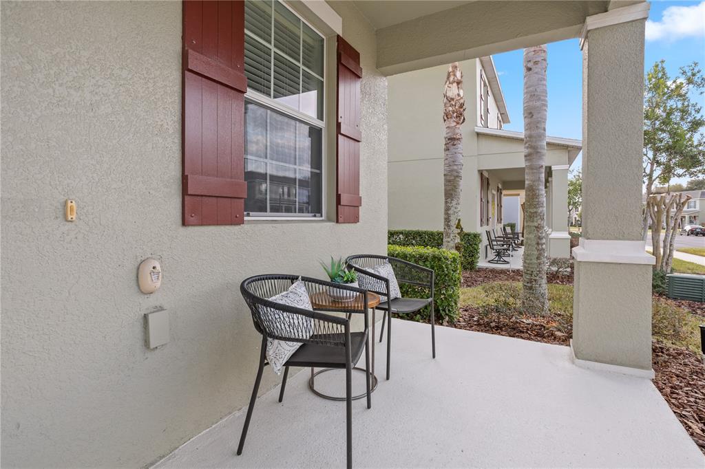 A covered front porch features two black chairs, a small table, and red window shutters — 1264 SEBURN ROAD, APOPKA, FL