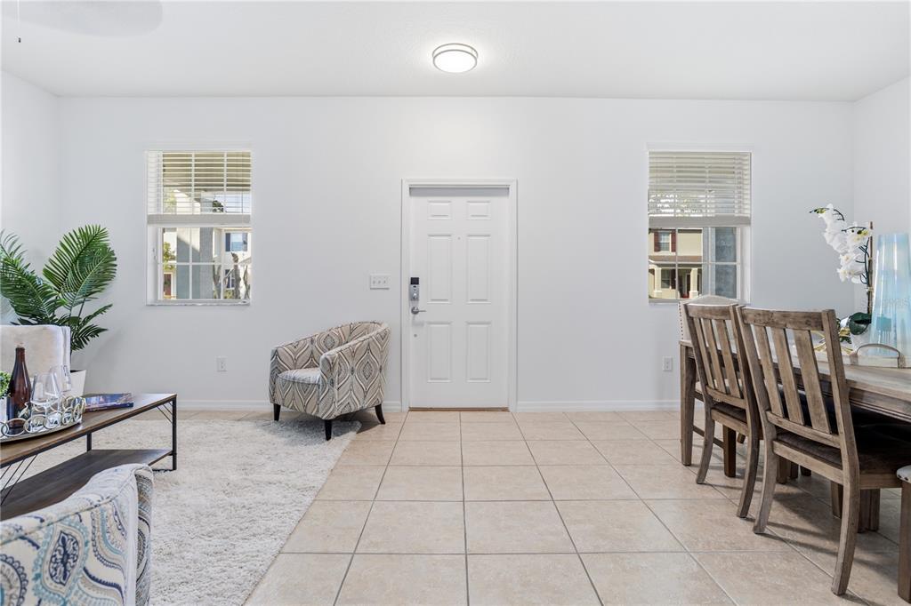 A bright living and dining area features white walls, tile flooring, and a front door — 1264 SEBURN ROAD, APOPKA, FL