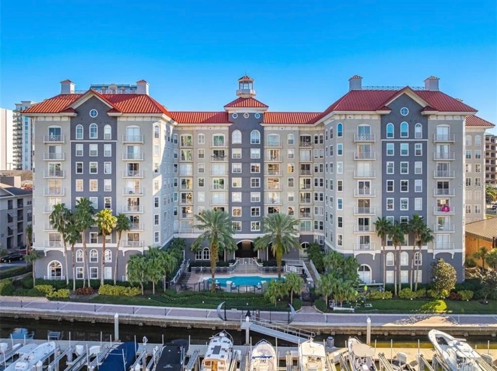 A multi-story apartment building with a red roof, central pool, and boat docks — 700 S HARBOUR ISLAND BOULEVARD UNIT 240, TAMPA, FL