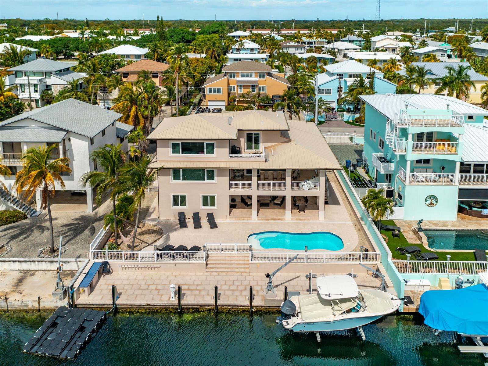 An aerial view shows a multi-story house with a pool, patio, and private boat dock — 397 Laguna Avenue, Key Largo FL 33037, KEY LARGO, FL