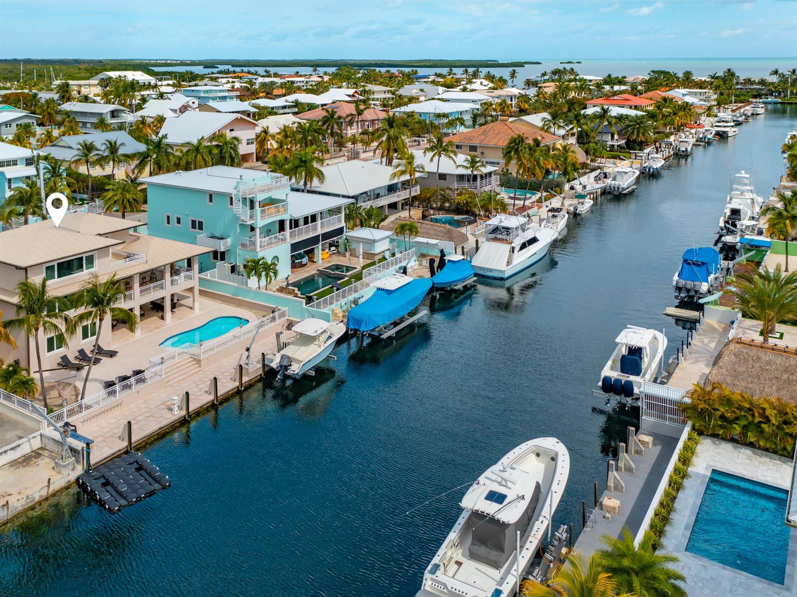 An aerial view shows waterfront houses with pools and boats docked in a canal — 397 Laguna Avenue, Key Largo FL 33037, KEY LARGO, FL