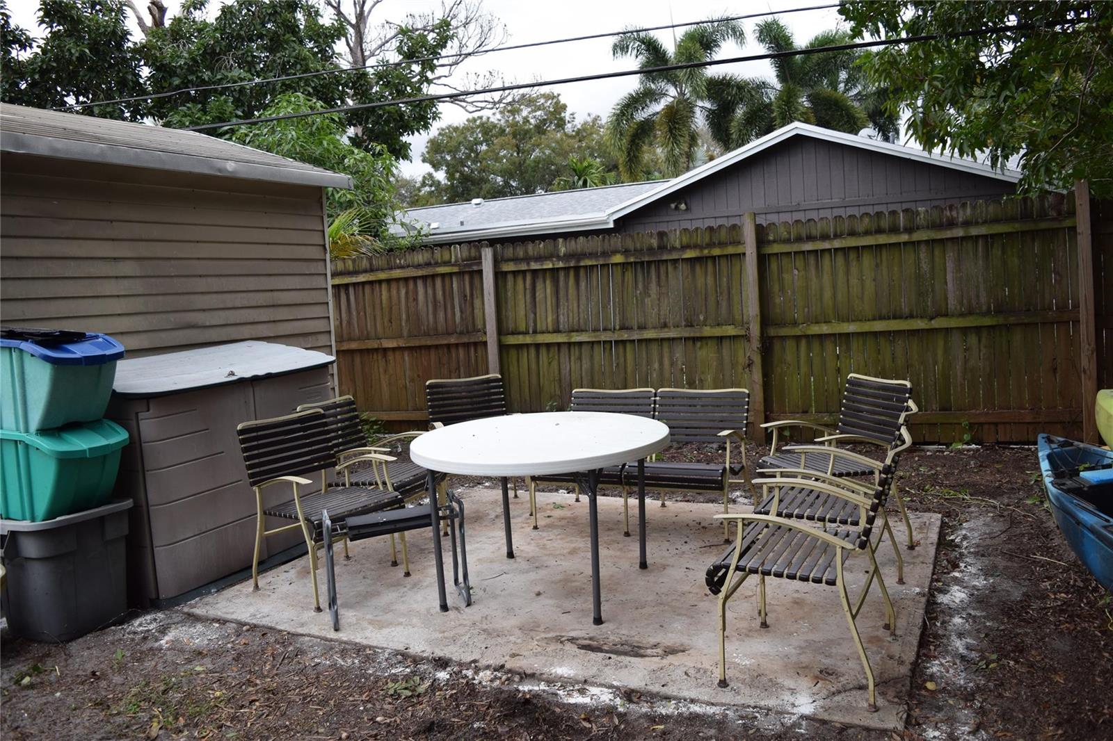 A backyard patio features a white round table, several chairs, and a storage shed — 3642 Harlowe Avenue, Boynton Beach FL 33436, BOYNTON BEACH, FL