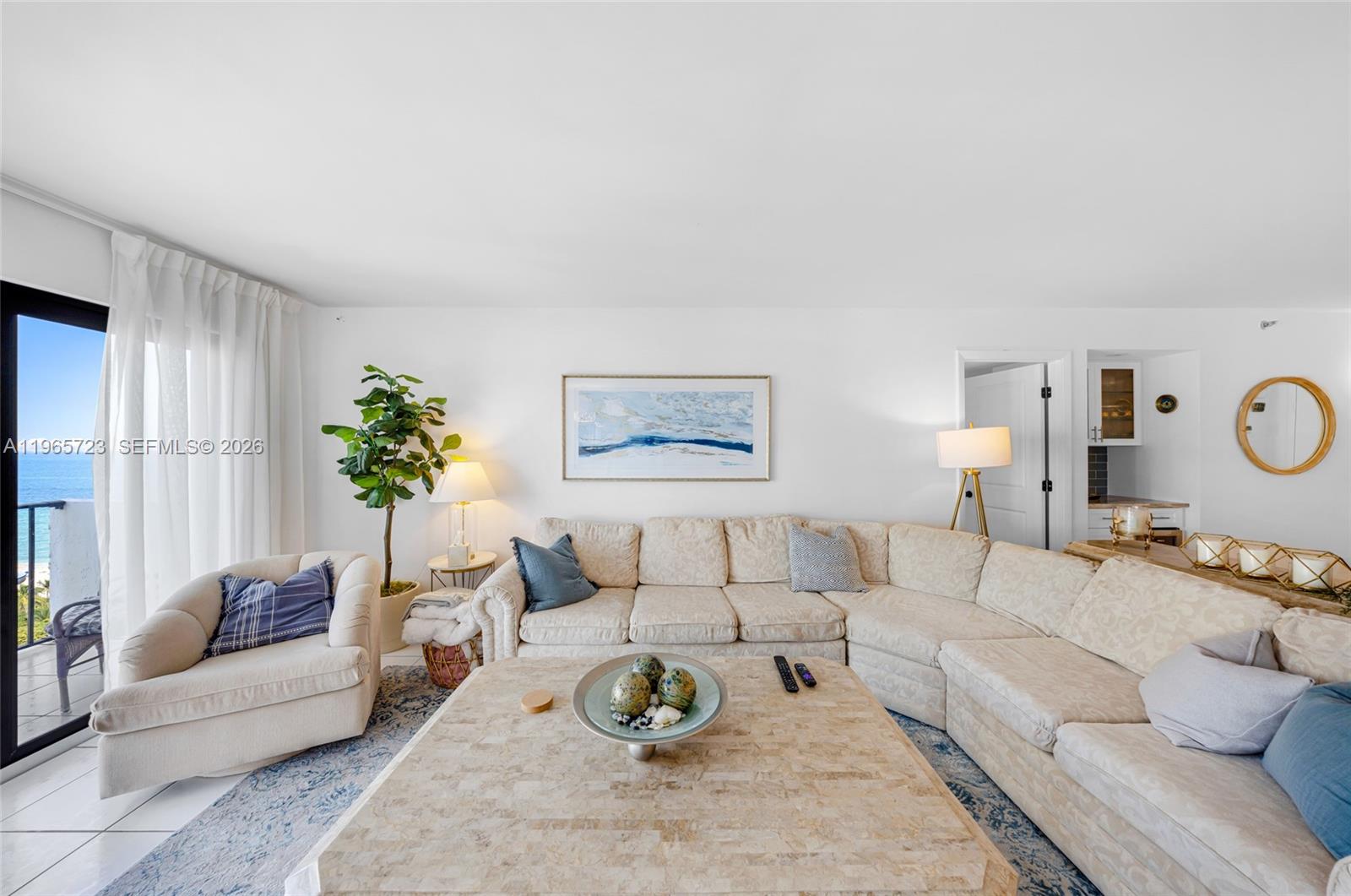 A living room features a large sectional sofa, a stone coffee table, and a balcony view — 1201 S Ocean Dr # 1903S, Hollywood FL 33019, HOLLYWOOD, FL