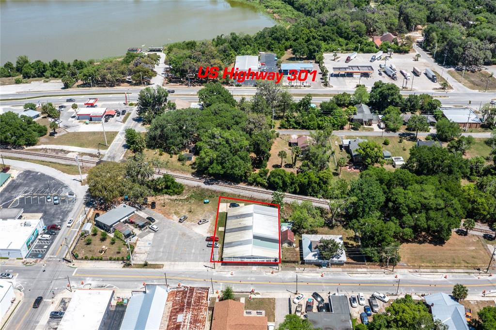 An aerial view shows a commercial building outlined in red near a railroad track — 6945 SE 221ST STREET, HAWTHORNE, FL
