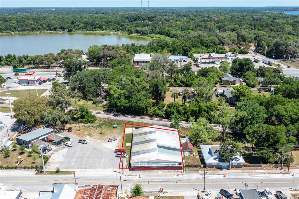 An aerial view shows a rectangular commercial building with a metal roof beside a parking lot — 6945 SE 221ST STREET, HAWTHORNE, FL