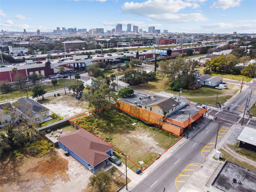 An aerial view shows a vacant rectangular lot bordered by a house and a commercial building — 2213 E COLUMBUS DRIVE, TAMPA, FL