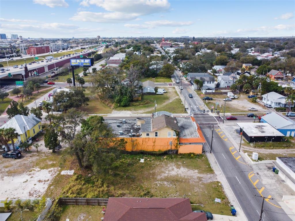 An aerial view shows a commercial building with an orange exterior wall near a road — 2213 E COLUMBUS DRIVE, TAMPA, FL