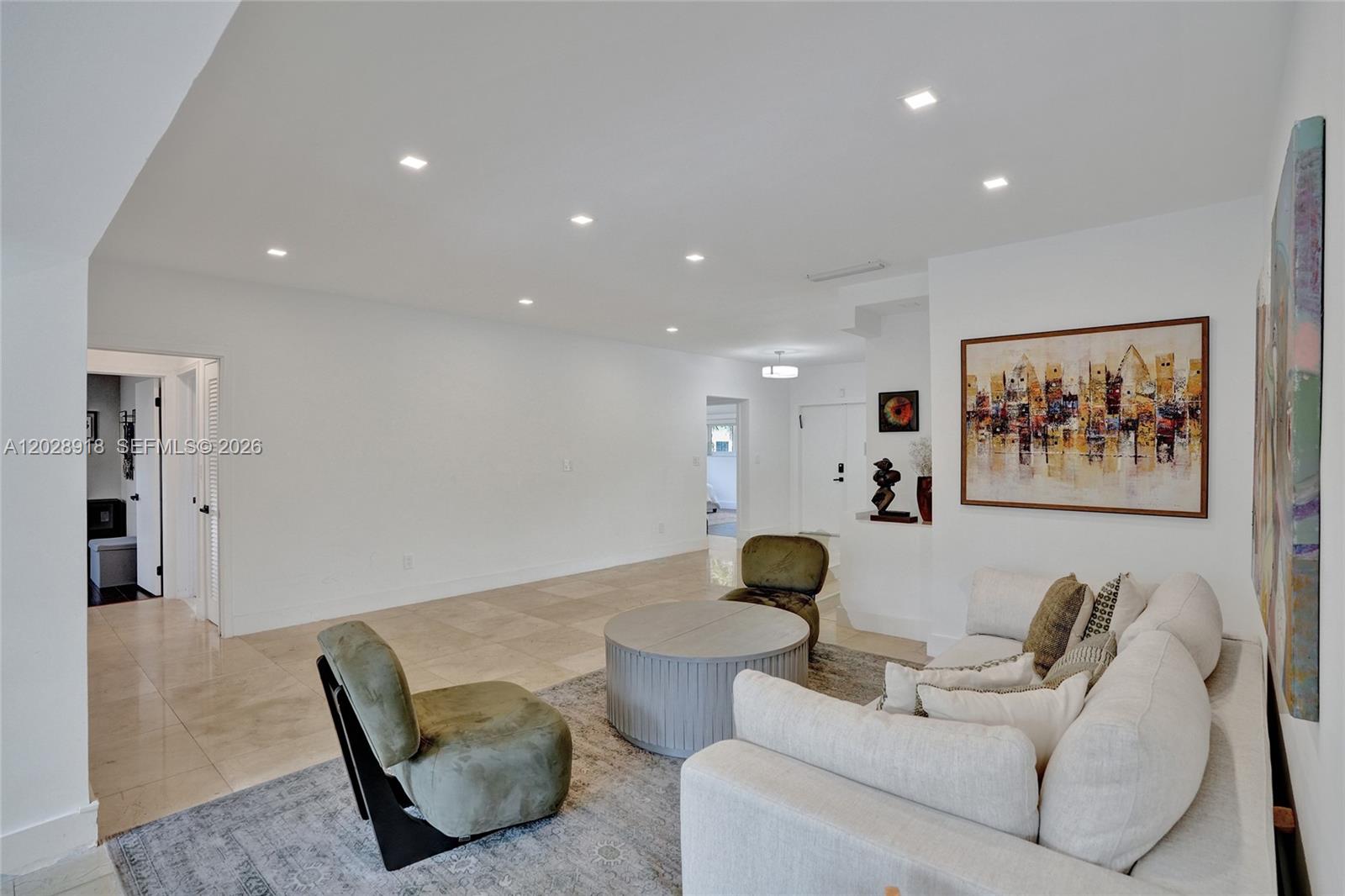 A living room features a white sofa, two green chairs, a round table, and artwork — 18641 NE 21st Ave, Miami FL 33179, MIAMI, FL