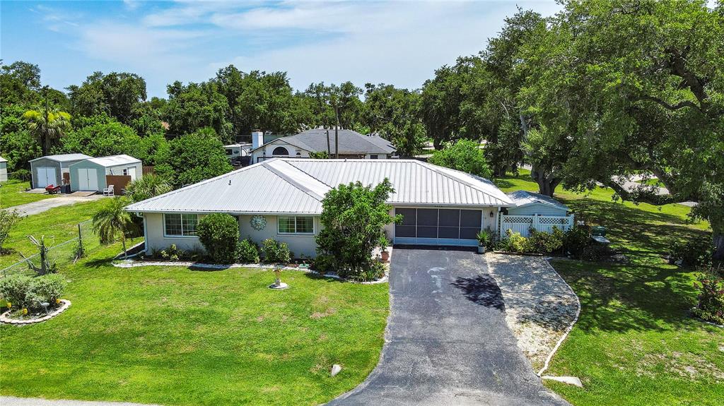 An aerial view of a single-story house with a metal roof and a paved driveway — 1175 BEAUMONT AVENUE, PORT CHARLOTTE, FL