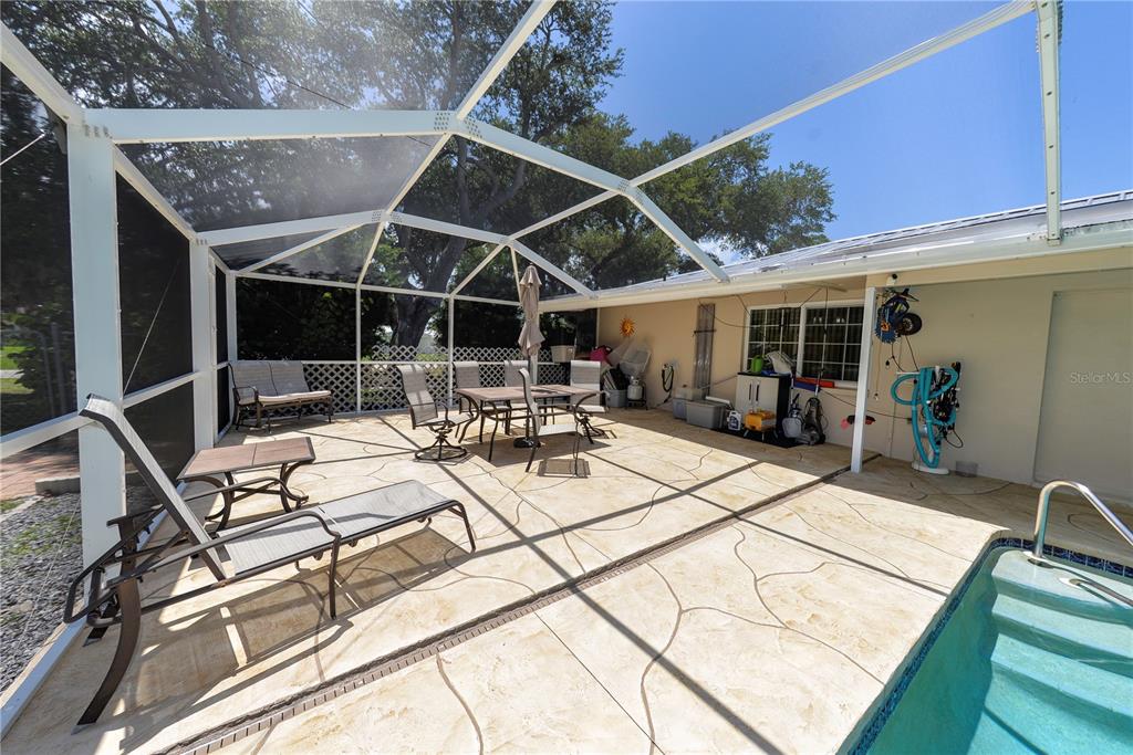 A screened-in patio features a concrete deck, outdoor furniture, and a swimming pool — 1175 BEAUMONT AVENUE, PORT CHARLOTTE, FL