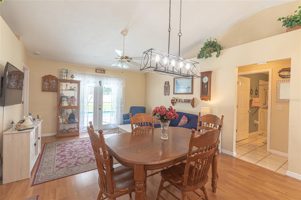 A dining area with a wooden table and chairs sits in front of a living space — 103 EASTWOOD DRIVE, PALM COAST, FL