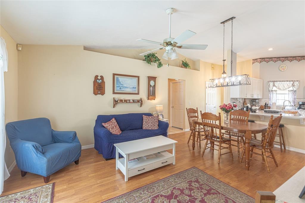A living and dining area features wood flooring, a blue sofa, and a wooden dining set — 103 EASTWOOD DRIVE, PALM COAST, FL