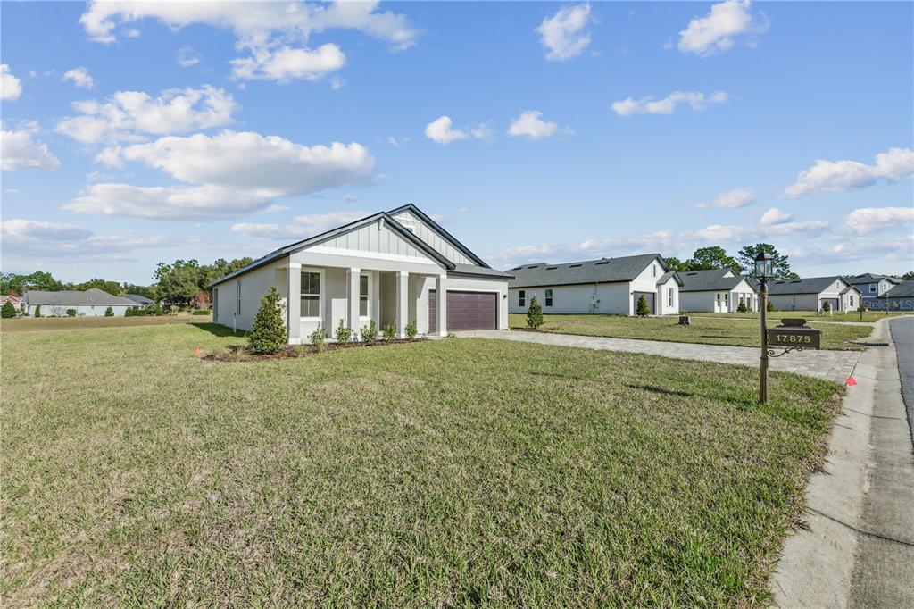 A single-story house with a gray exterior and a paved driveway sits on a lawn — 17875 SW 68TH PLACE, DUNNELLON, FL
