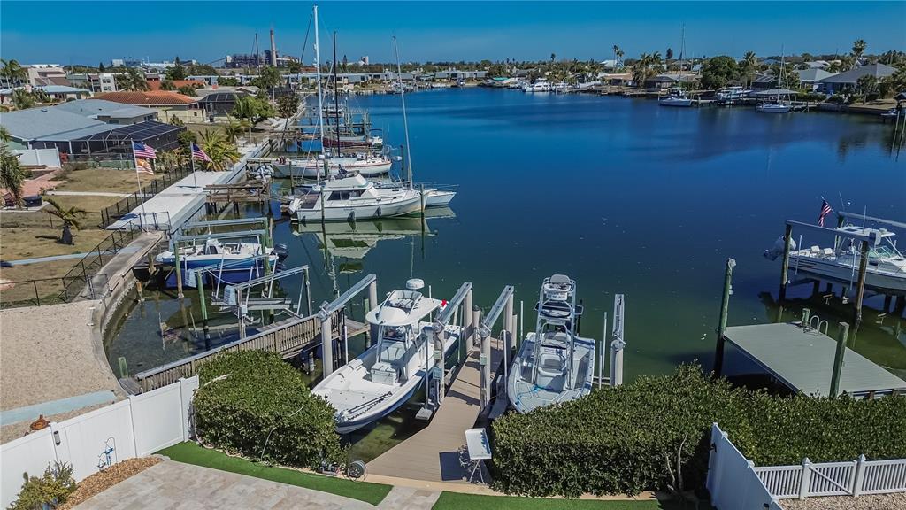 An aerial view shows a residential canal with multiple docked boats and private boat lifts — 6404 LAKE SUNRISE DRIVE, APOLLO BEACH, FL