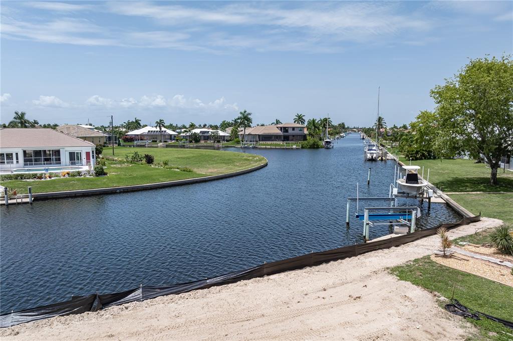 An elevated view of a residential canal with boat docks and surrounding waterfront homes — 5143 ALMAR DRIVE, PUNTA GORDA, FL