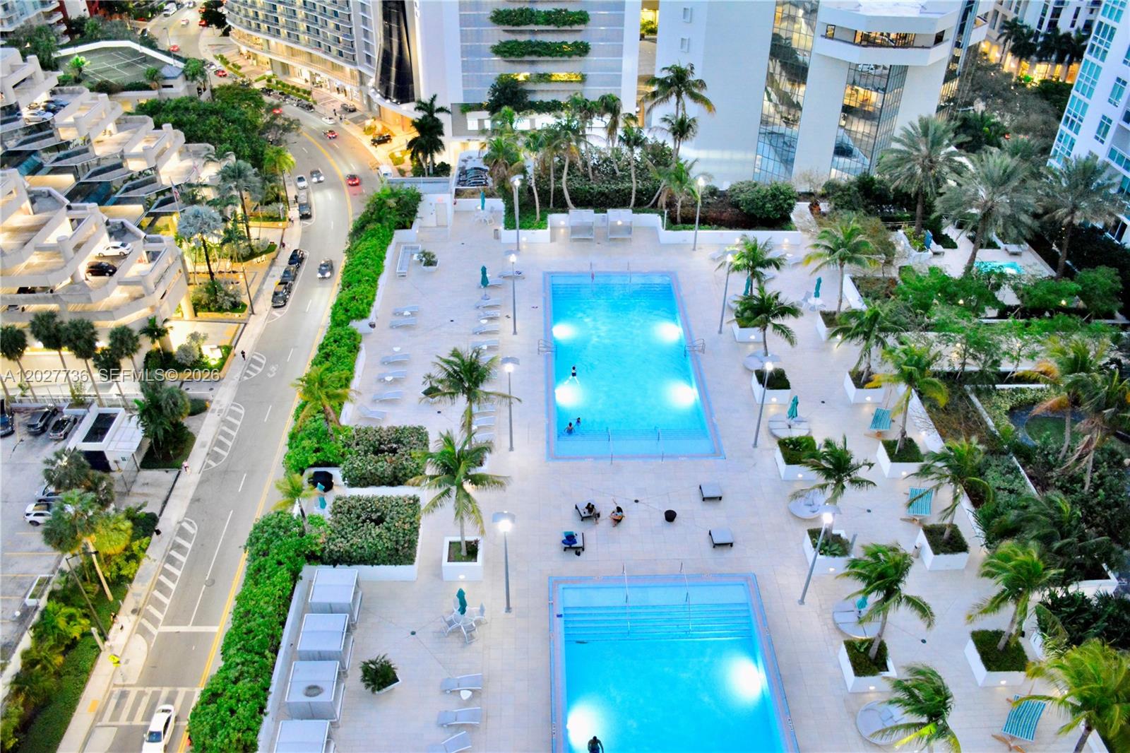An aerial view shows two rectangular swimming pools surrounded by palm trees and lounge chairs — 951 BRICKELL # 2609, Miami FL 33131, MIAMI, FL