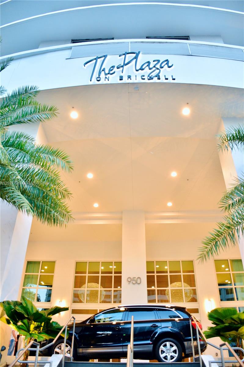 The exterior entrance of a building features a sign reading The Plaza on Brickell — 951 BRICKELL # 2609, Miami FL 33131, MIAMI, FL