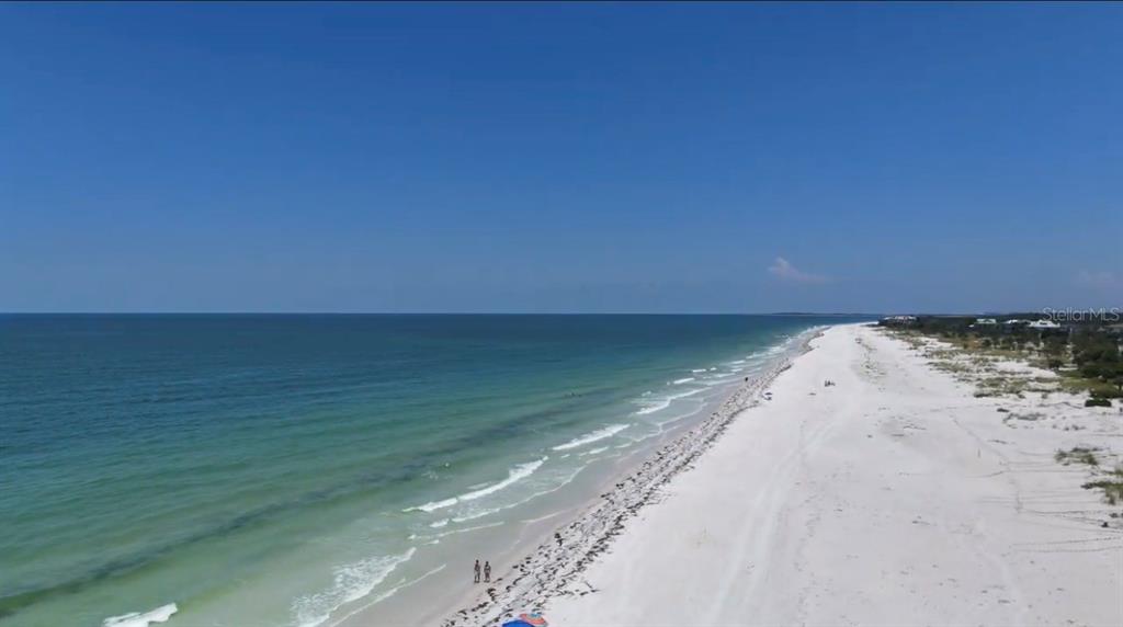 An aerial view of a white sand beach meeting the ocean under a clear sky — 880 MANDALAY AVENUE UNIT C808, CLEARWATER BEACH, FL