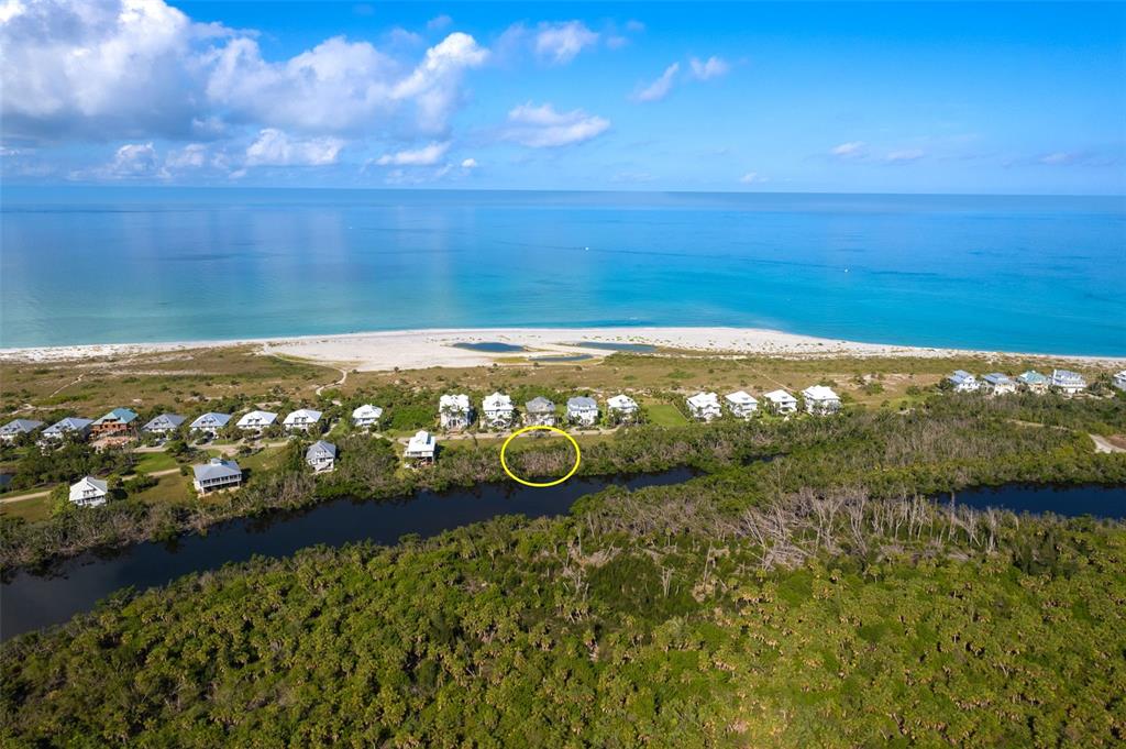 An aerial view shows a row of coastal houses near a beach and a waterway — 7061 PALM ISLAND DRIVE Lot 69, PLACIDA, FL