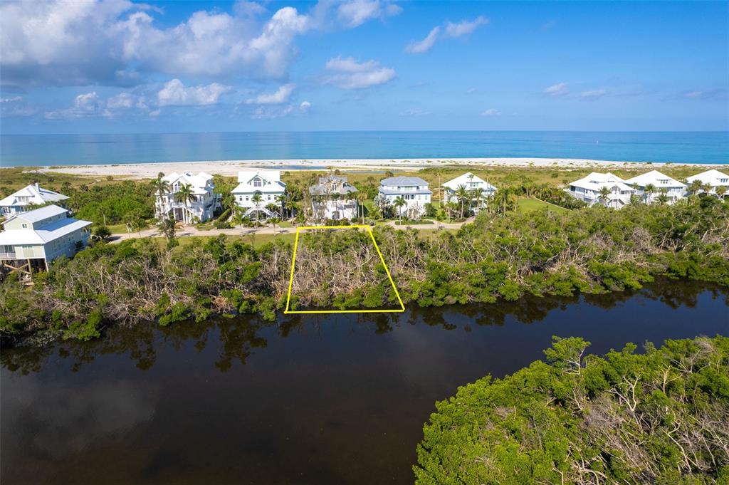 An aerial view shows a vacant, tree-covered lot outlined in yellow near a coastal waterway — 7061 PALM ISLAND DRIVE Lot 69, PLACIDA, FL