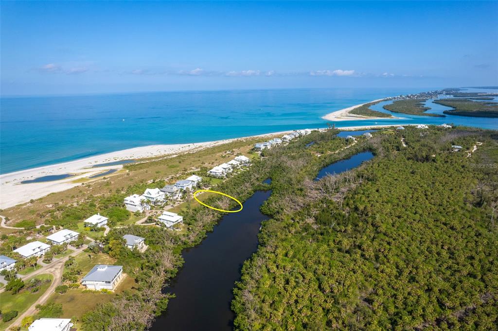 An aerial view shows a coastal landscape with houses, a waterway, and a beach — 7061 PALM ISLAND DRIVE Lot 69, PLACIDA, FL