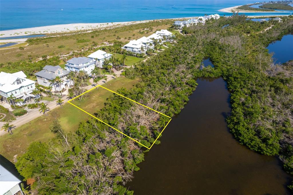 An aerial view shows a vacant rectangular lot bordered by a mangrove-lined waterway and houses — 7061 PALM ISLAND DRIVE Lot 69, PLACIDA, FL
