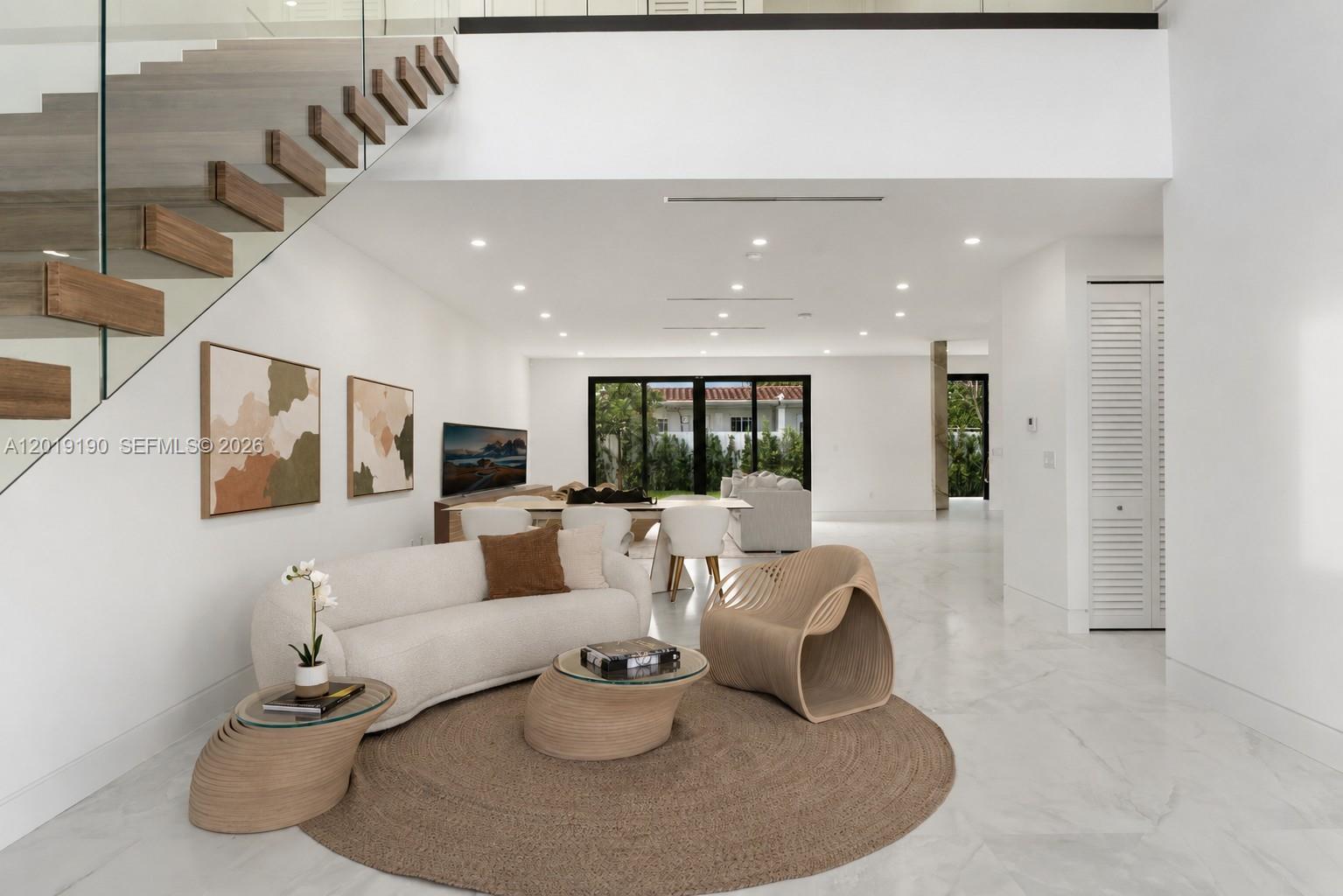 A modern living room features a floating staircase, white walls, and light-colored tile flooring — 2265 SW 4 St, Miami FL 33135, MIAMI, FL