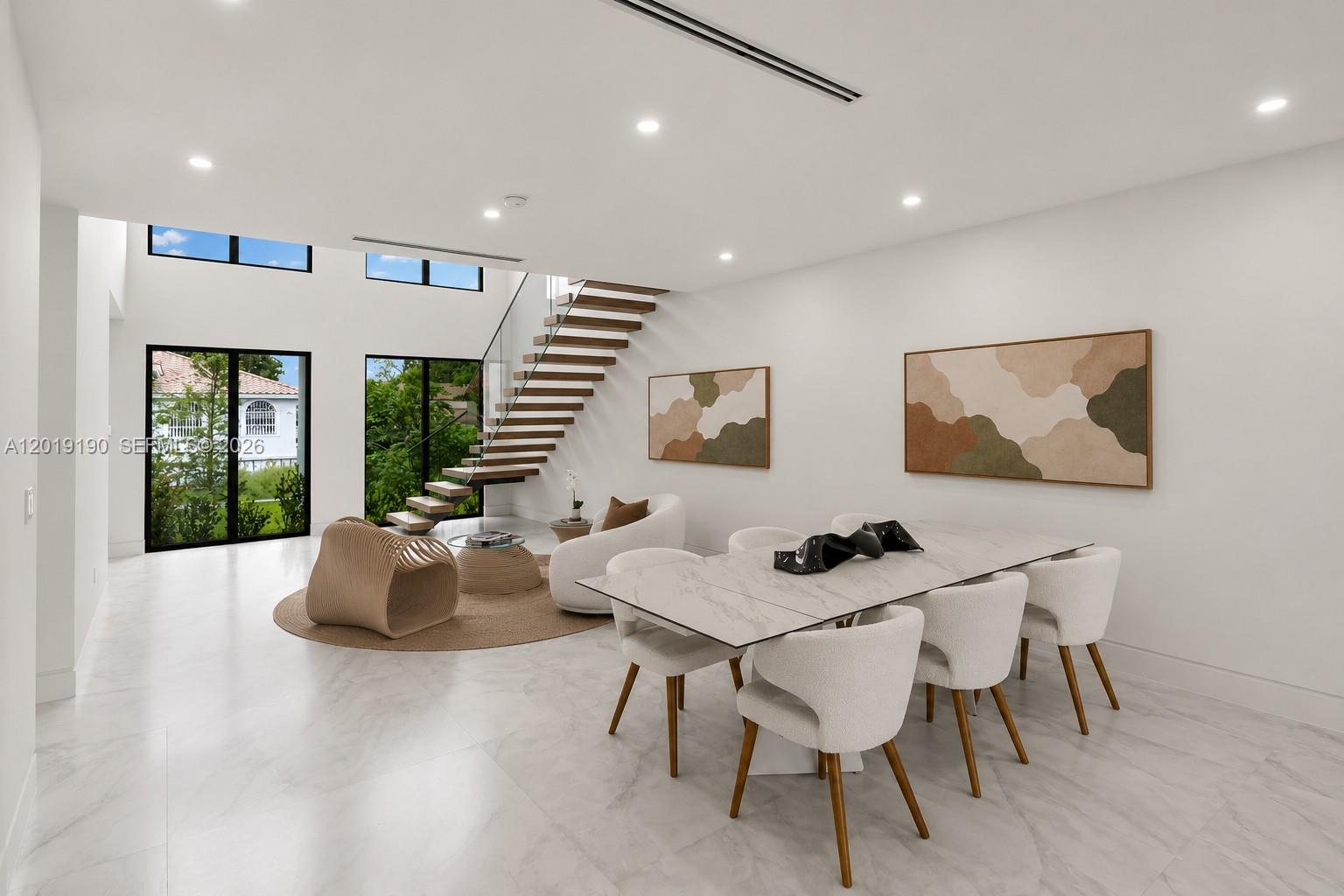 A modern open-plan dining and living area features a floating staircase and marble flooring — 2265 SW 4 St, Miami FL 33135, MIAMI, FL
