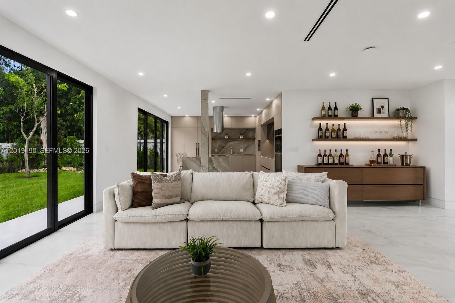 A modern living room features a white sofa, a glass coffee table, and a bar area — 2265 SW 4 St, Miami FL 33135, MIAMI, FL