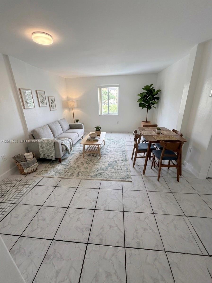 A living and dining area features white walls, tile flooring, a sofa, and a table — 2745 W Okeechobee Rd # 5, Hialeah FL 33010, HIALEAH, FL