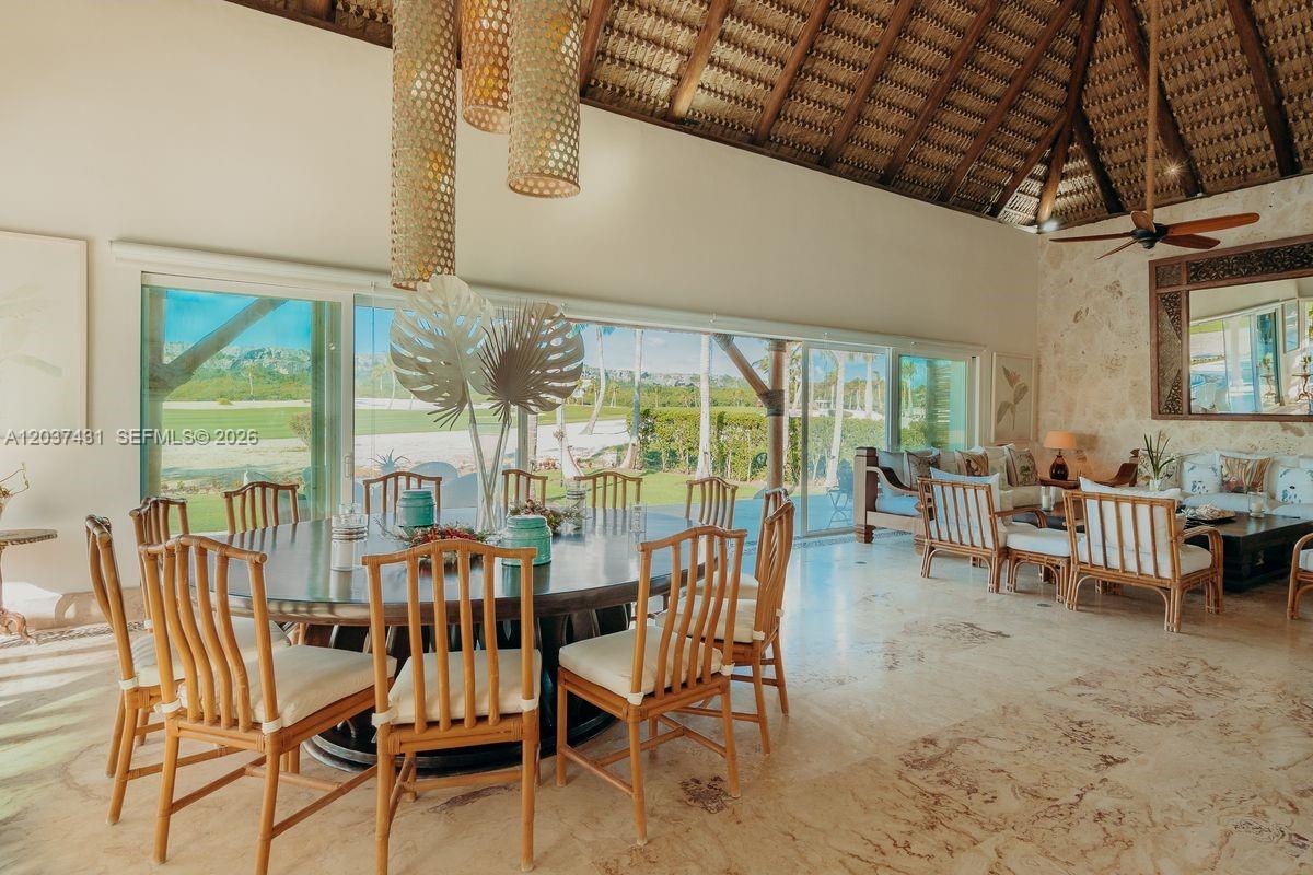 A dining area with a round table and bamboo chairs sits before large glass doors — 0 Caleton estate, FL, FL