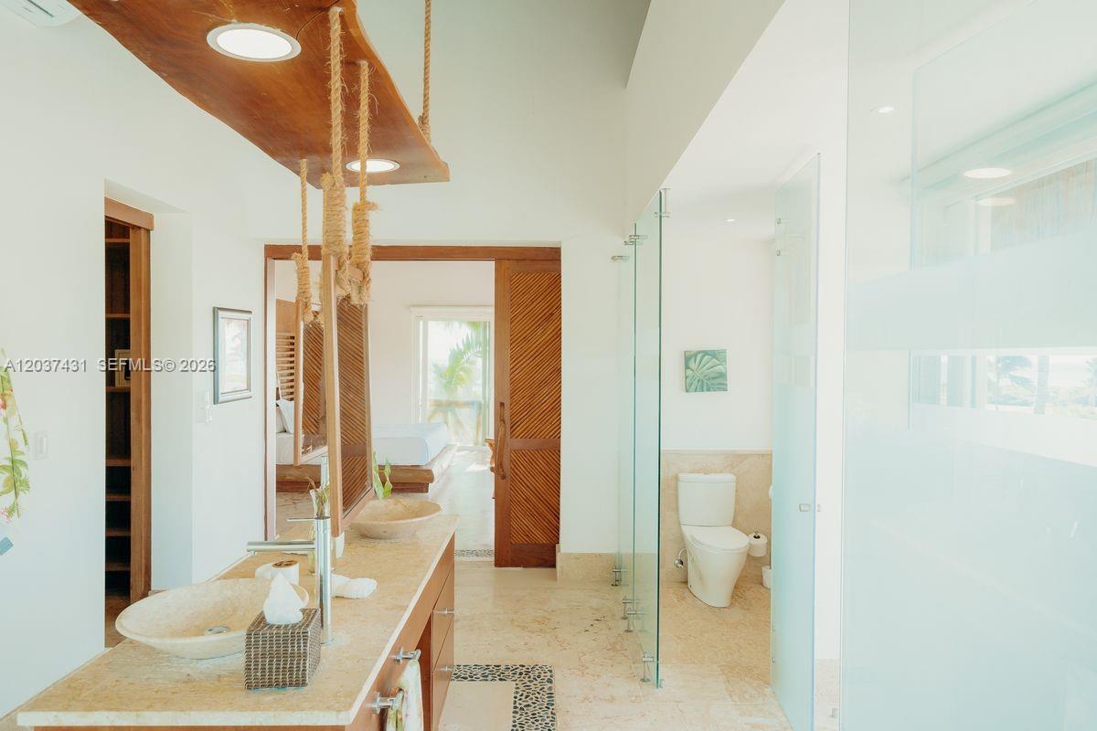 A bathroom features a stone vanity with vessel sinks, a glass-enclosed shower, and a toilet — 0 Caleton estate, FL, FL