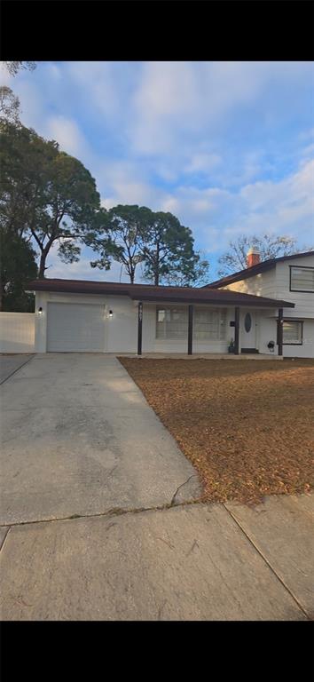 A single-story house with a white exterior, a garage, and a covered front porch — 7907 W HIAWATHA STREET, TAMPA, FL