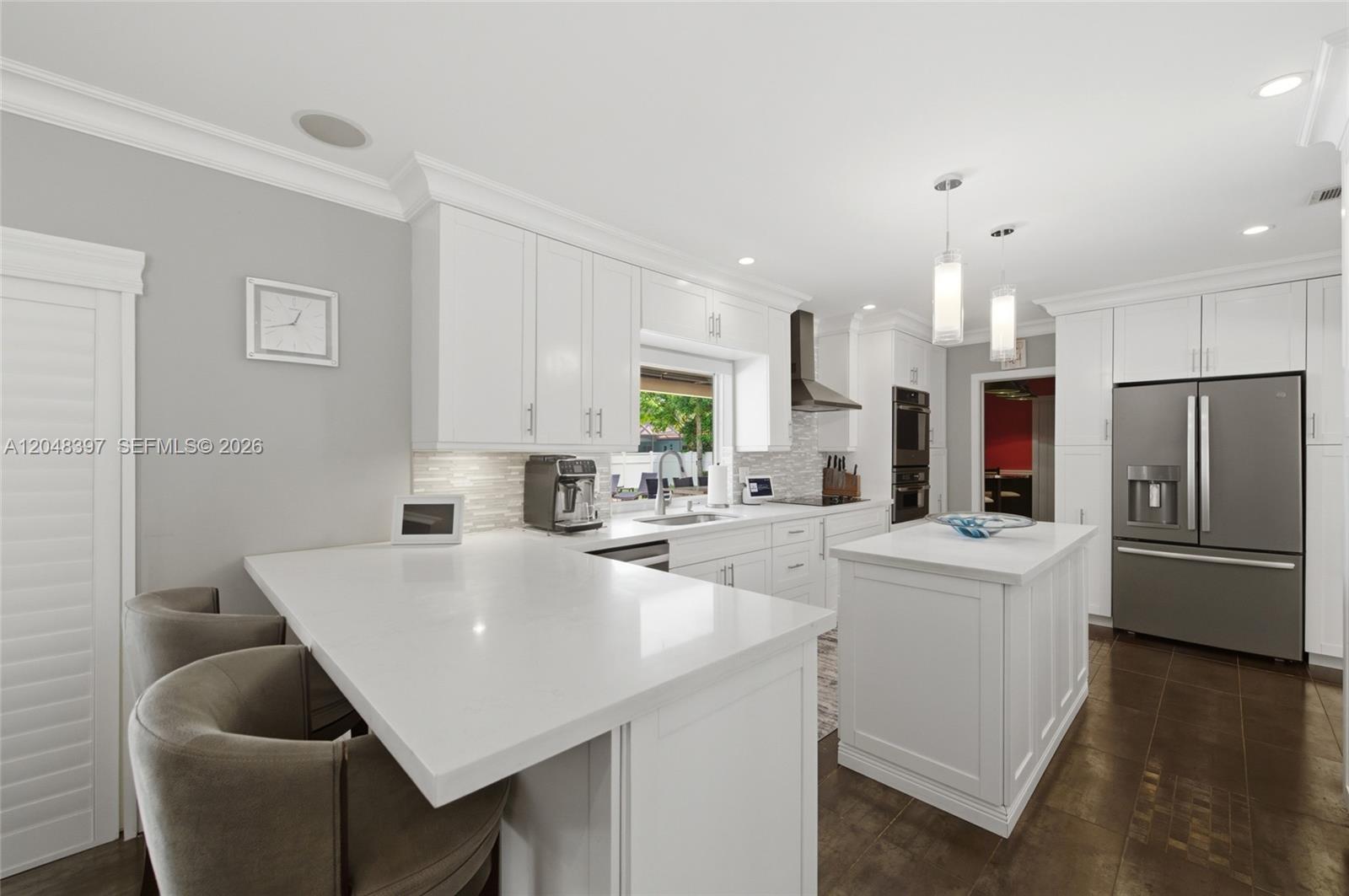 A modern white kitchen features a central island, quartz countertops, and stainless steel appliances — 621 NW 74th Ave, Plantation FL 33317, PLANTATION, FL